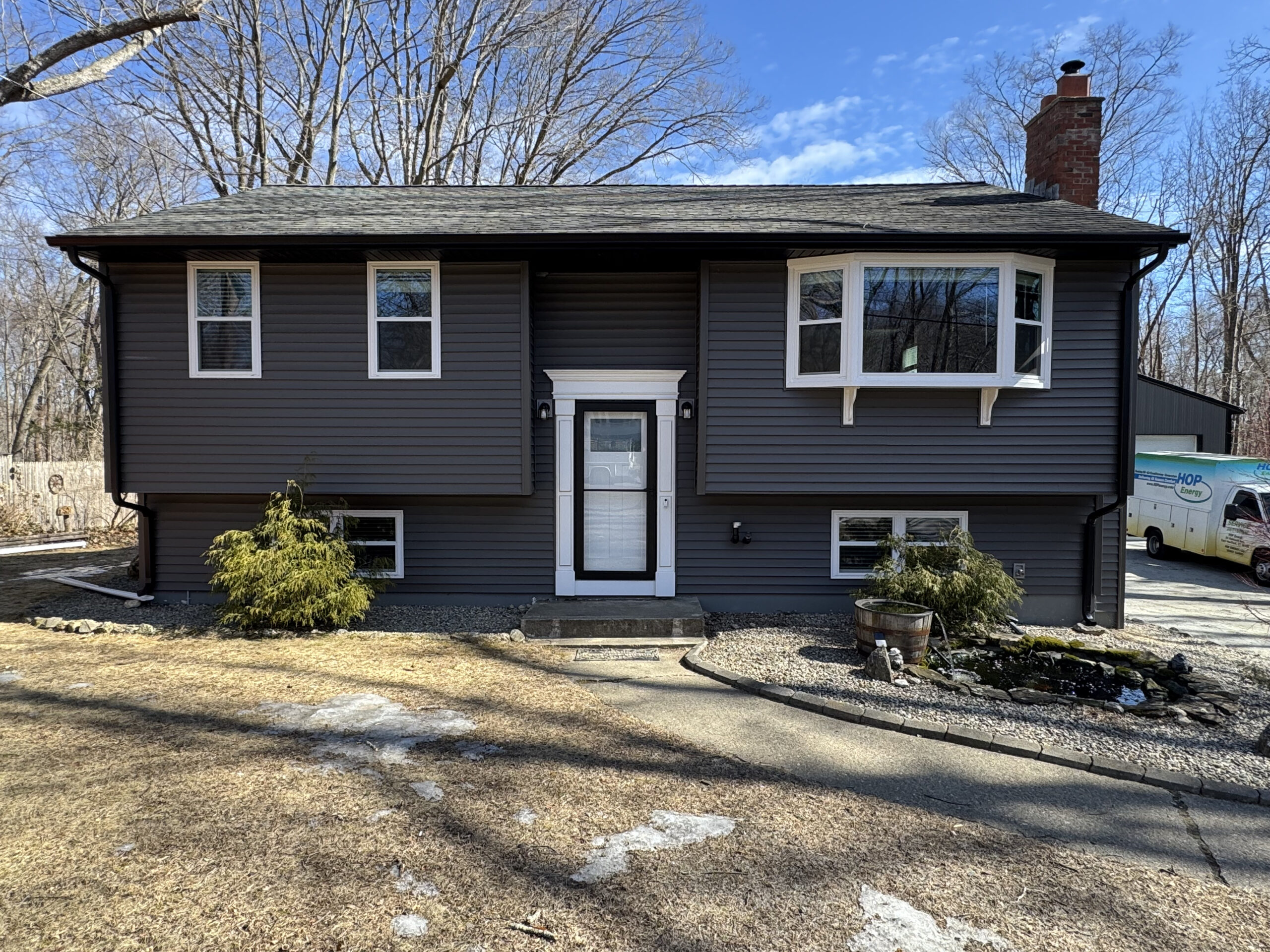Completed split-level home with new dark vinyl siding built by Lagace Construction