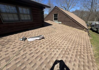 New shingle roof installed by Lagace Construction on a residential log cabin in Andover, CT