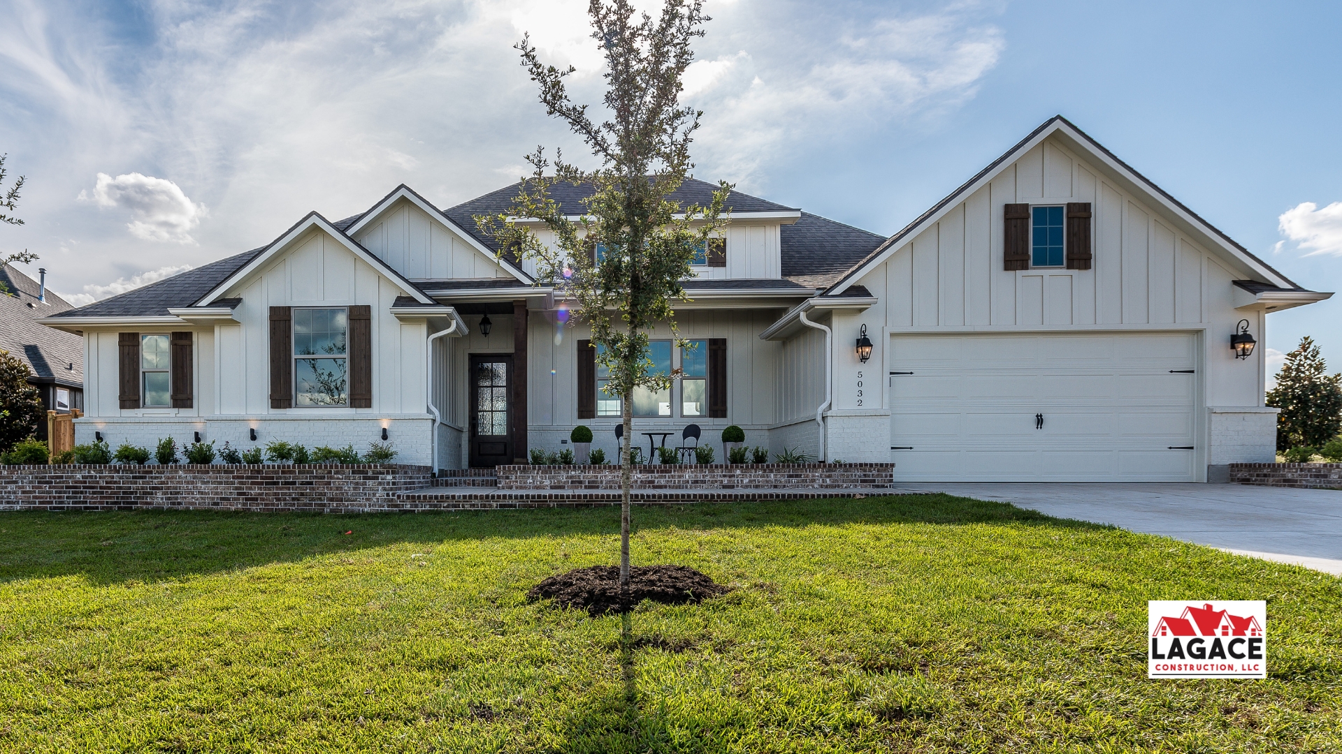 Modern farmhouse in Hebron, CT with board-and-batten siding, rustic wood shutters, and a covered front porch, built by Lagace Construction.